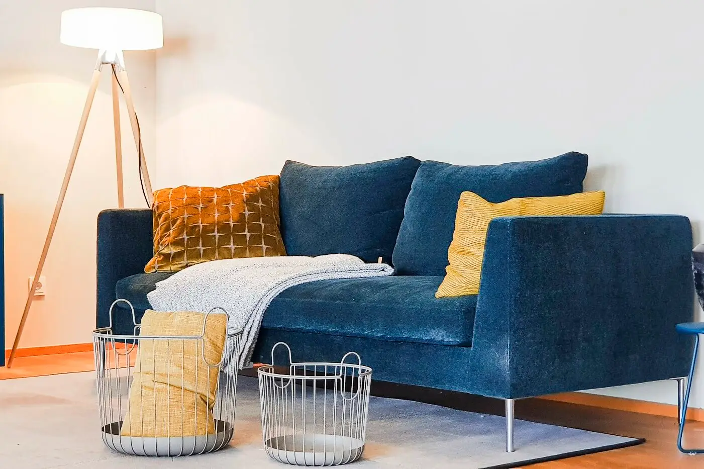 Gemütliches Wohnzimmer mit blauem Sofa, Stehleuchte und dekorativen Kissen, Portfolio Nicole Hafen, das wohnwerk